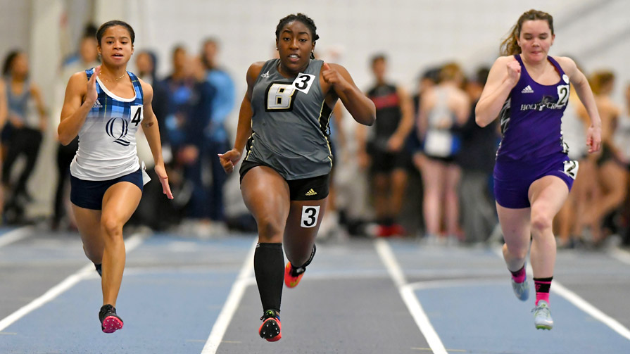 Three women sprinting with Bryant athlete in middle.