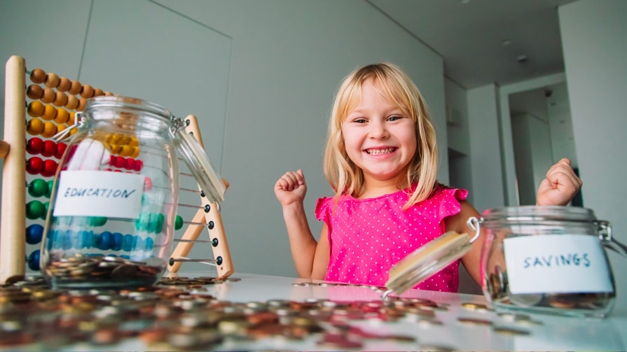 Young girl with two money jars and pennies.