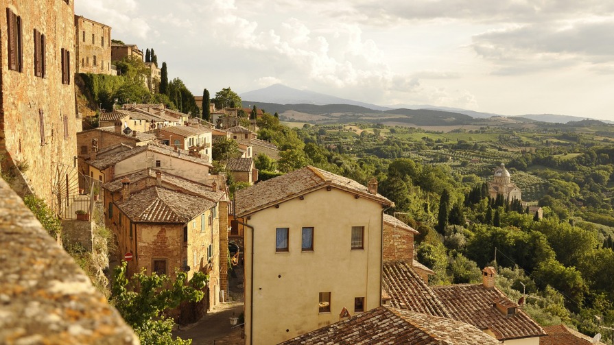 Tuscany village overlooking trees.