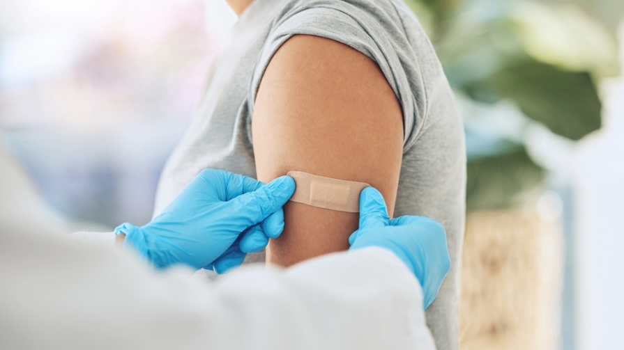 Doctor places Band-Aid on arm after flu shot.
