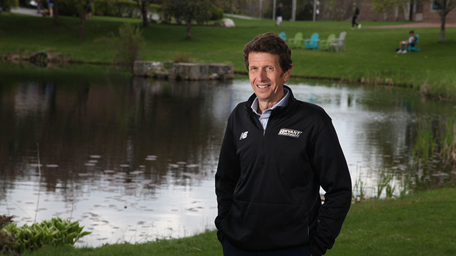 President Ross Gittell stands beside the pond at Bryant University