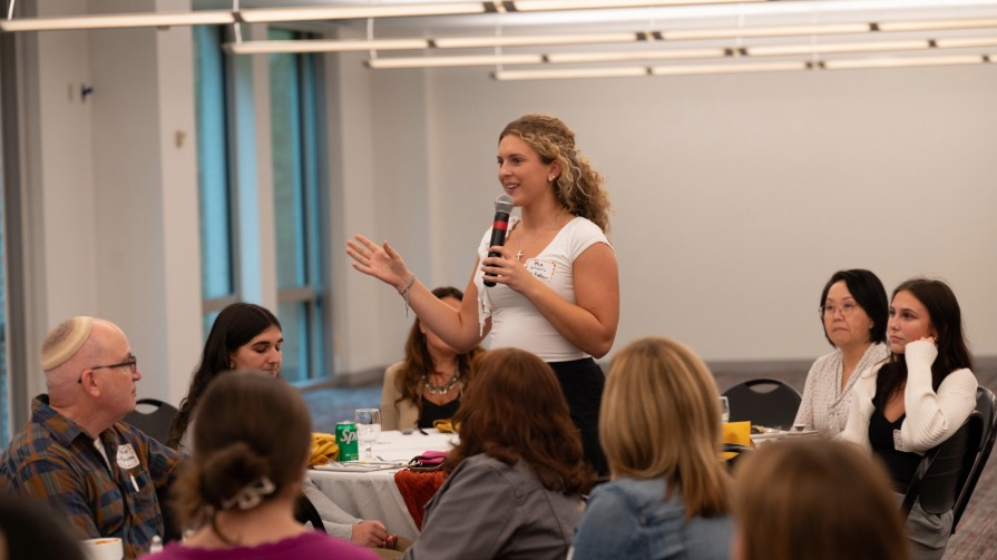 Ellen Wilson Fellow Mia DeAngelis '28 introduces herself and shares her favorite leader at the Fellowship's opening reception.