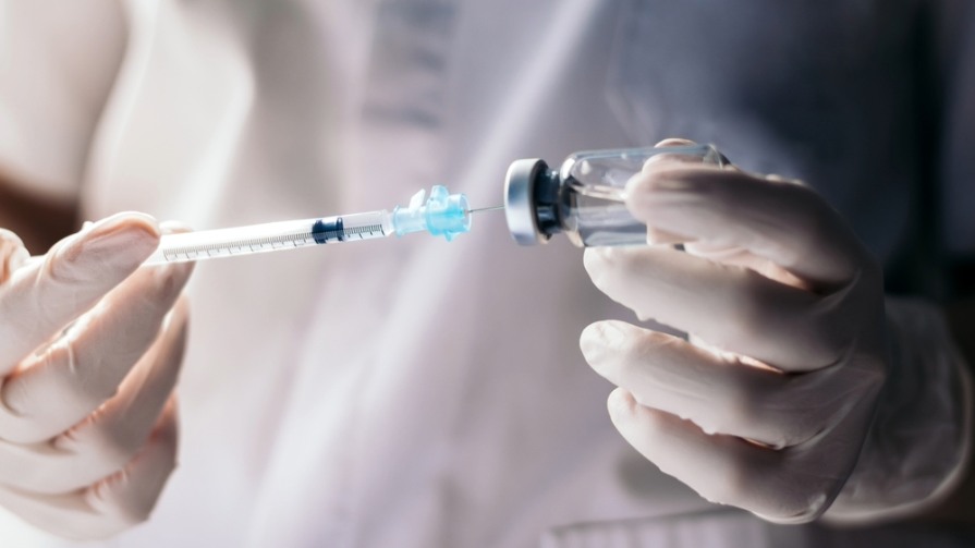 Researcher holding vaccine.