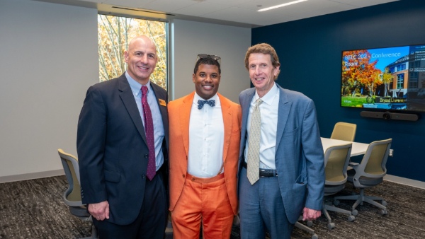 Bruce Messier ’14, poses for a photo with Bryant University President Ross Gittell, Ph.D., and Todd Alessandri, Ph.D., dean of the College of Business, in the Butler & Messier Insurance Agency Conference Room.