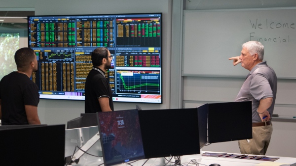 Executive and Residence and Finance Department Chair Kevin Maloney demonstrates the capabilities of the new Financial Markets Center.