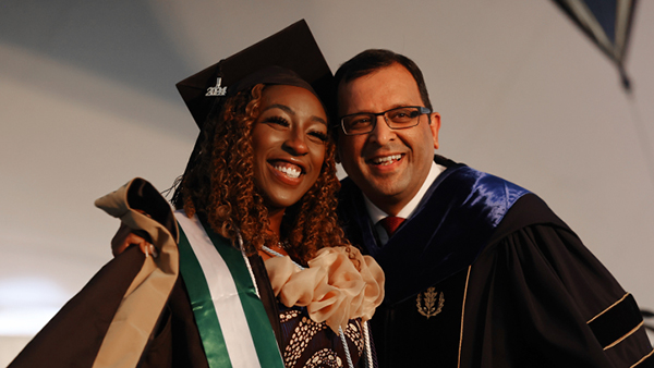 Patricia Adensaya '23, '24MBA poses with Provost and Chief Academic Officer Rupendra Paliwal, Ph.D. during Byant's Graduate Commencement ceremony 