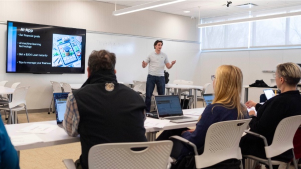 A student presents "Finance Buddy" at the Bryant University Prompt-A-Thon