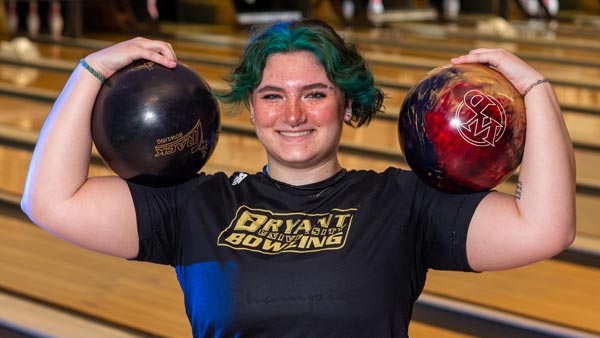 athlete holding two bowling balls.