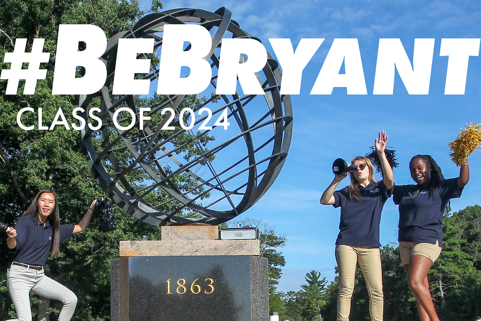 Students stand with Bryant globe sculpture at campus entrance