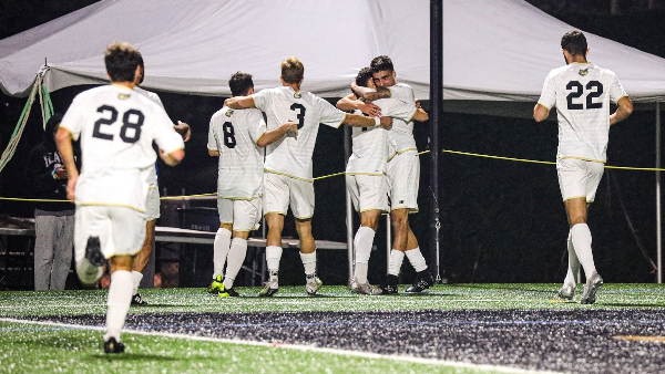 Bryant soccer players celebrate goal.