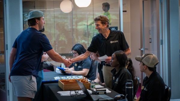 Bryant's Ross Gittell shakes hands with first-year student.