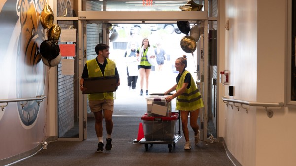 Students carry boxes to dorms.