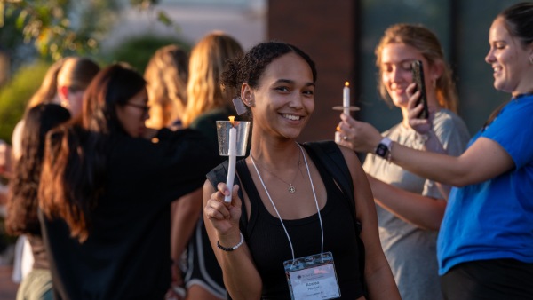 Bryant student holds candle at IgNIGHT ceremony.