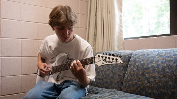 Boy plays guitar.